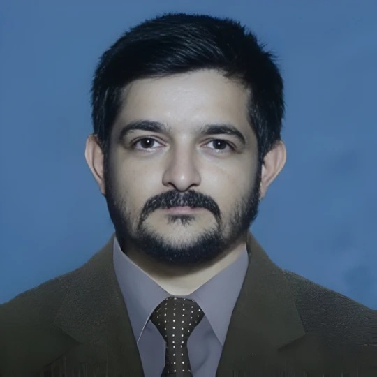 Professional headshot of Shyam Sundara Bhat, founder of Madhumakshika and a client of Growth Up PR Agency, wearing a brown suit and tie against a blue background.